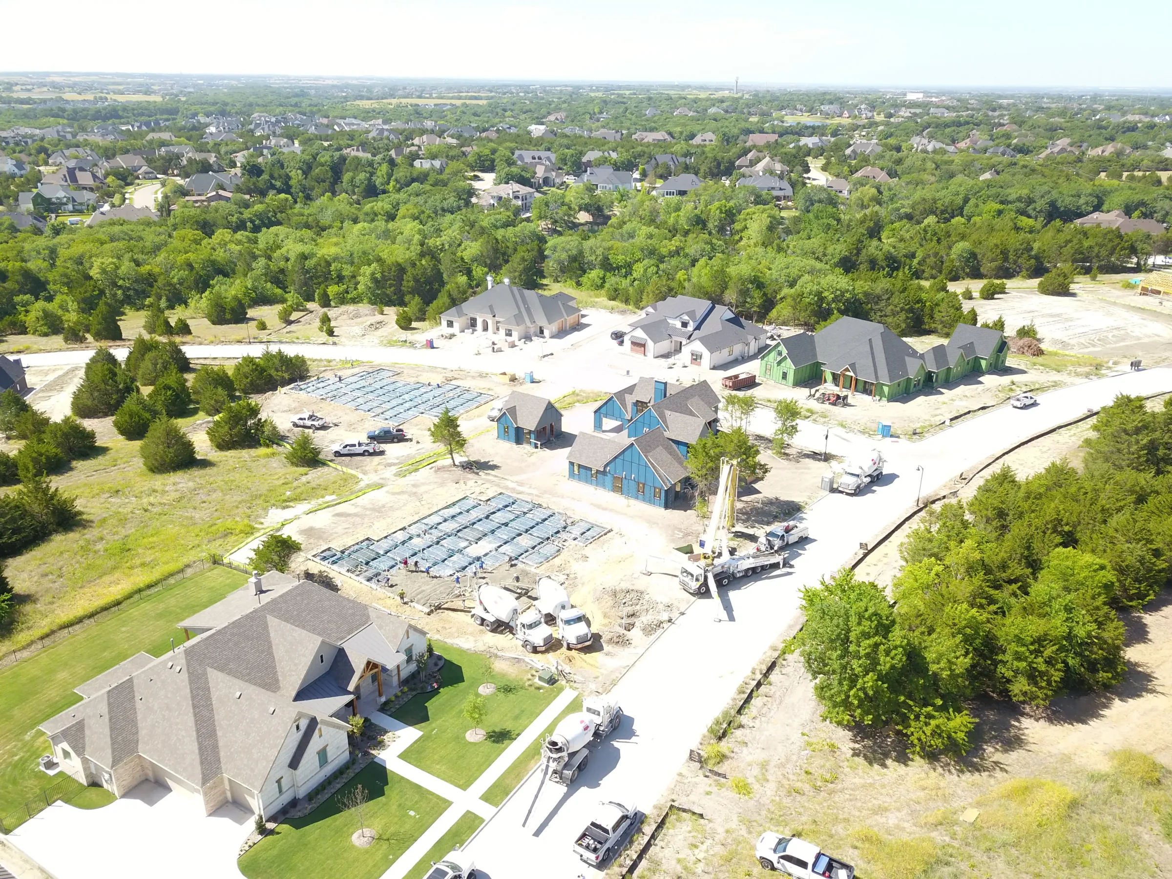 Aerial view of a custom home site looking down the drive, in daylight on a job site