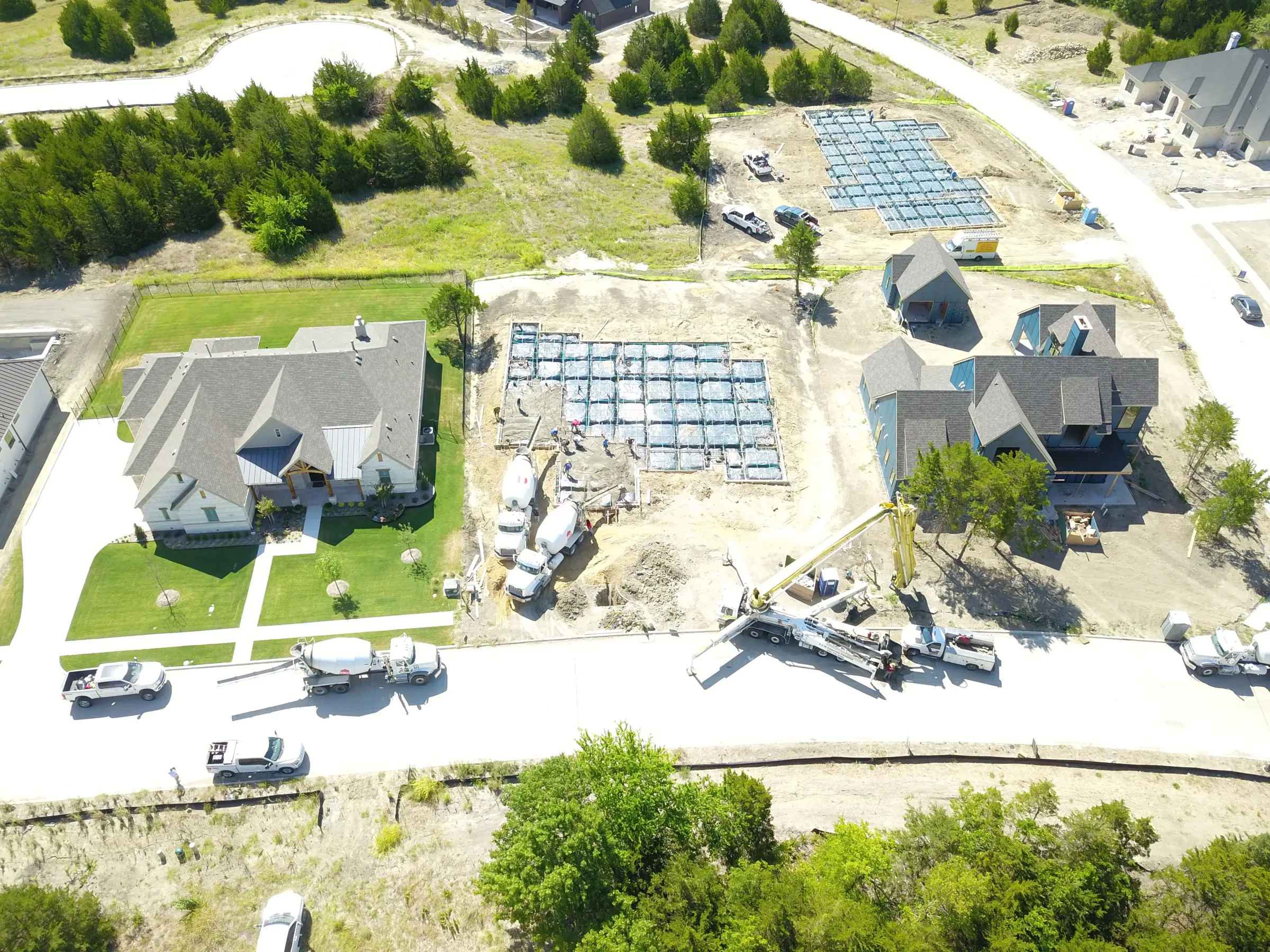 Aerial view of a custom home site over the roofline, in daylight on a job site