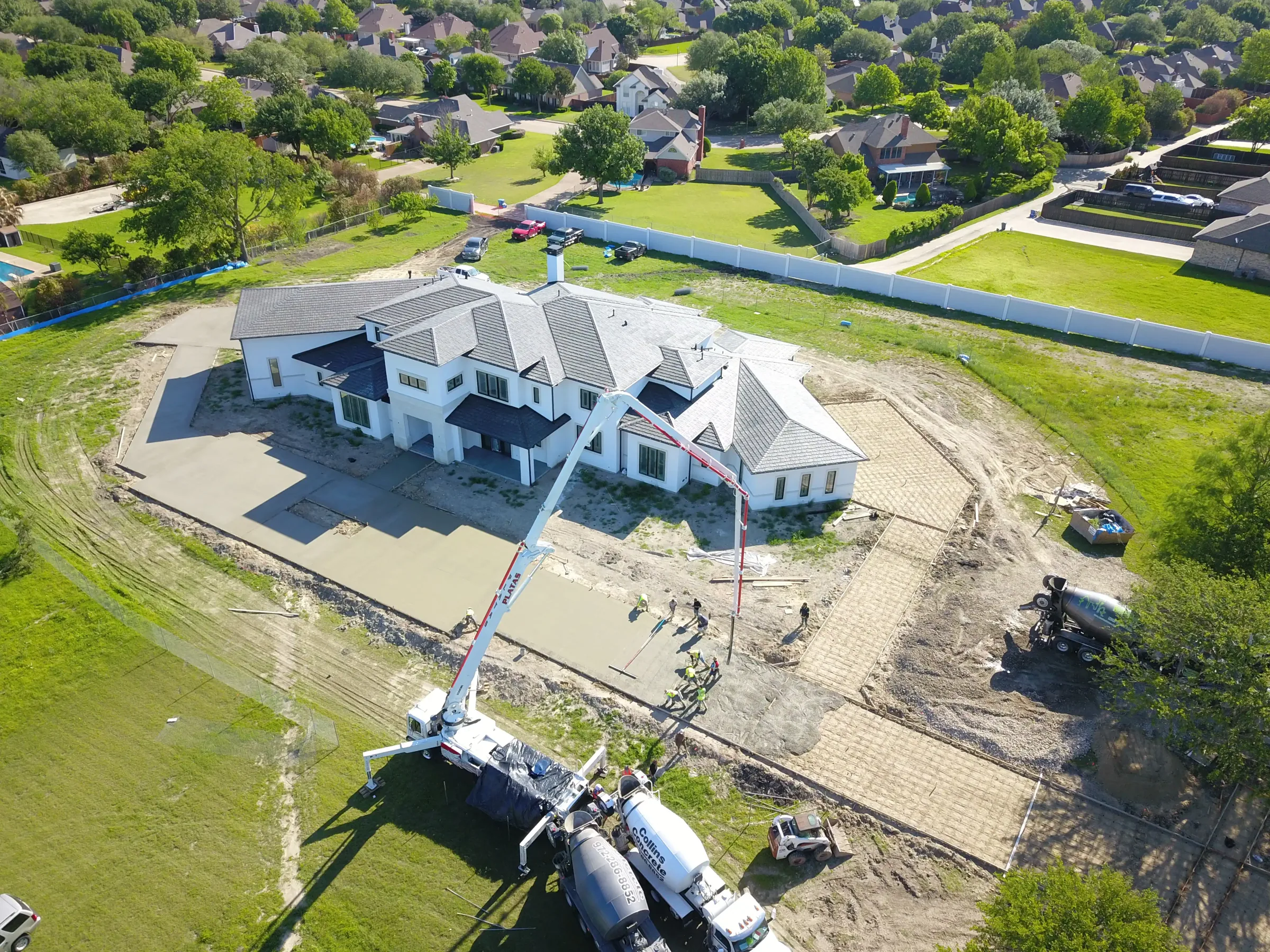 Aerial view of a custom home site from the rear of the property, in daylight on a job site