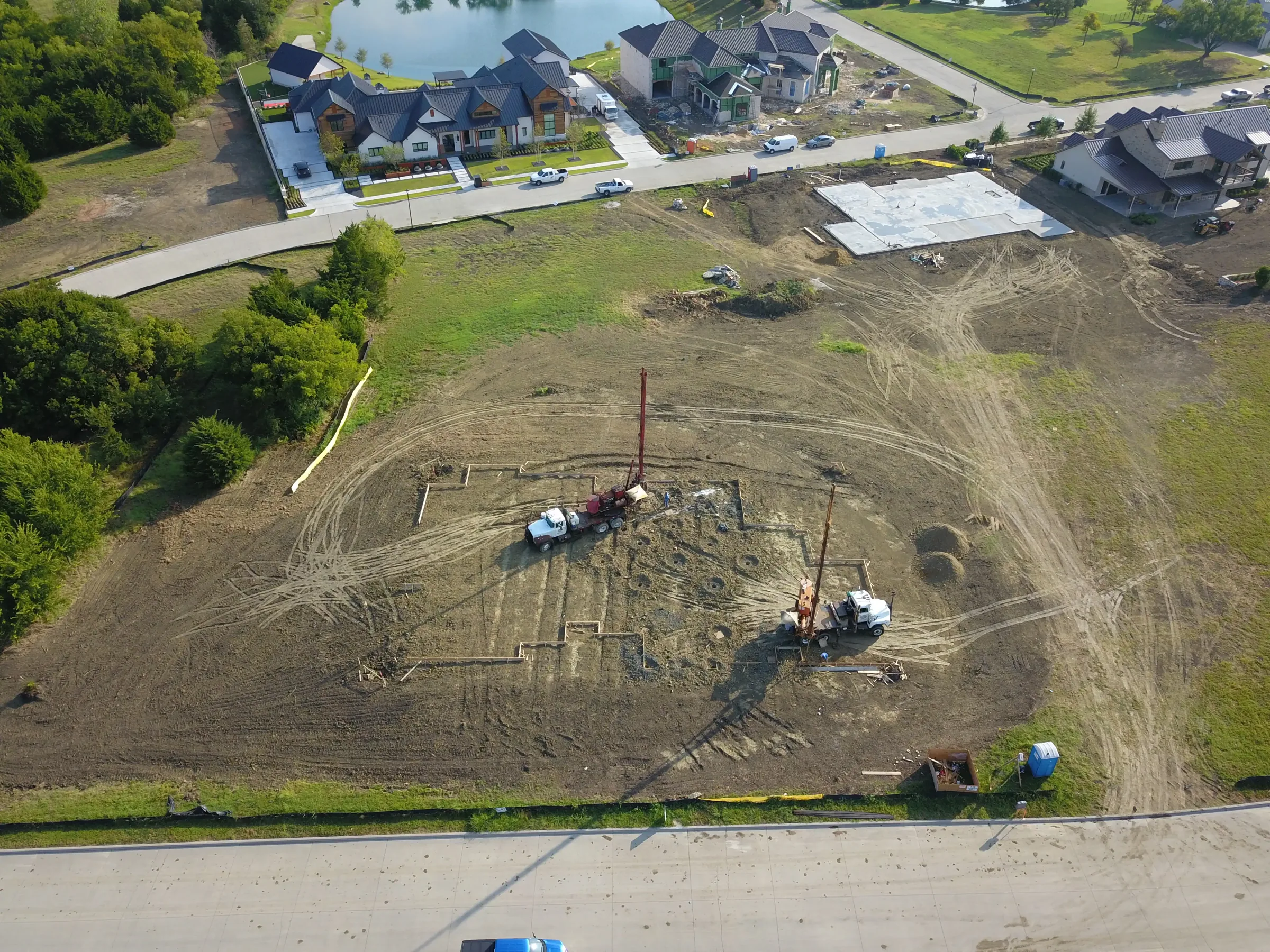Aerial view of a custom home site from above, from a second position on a job site