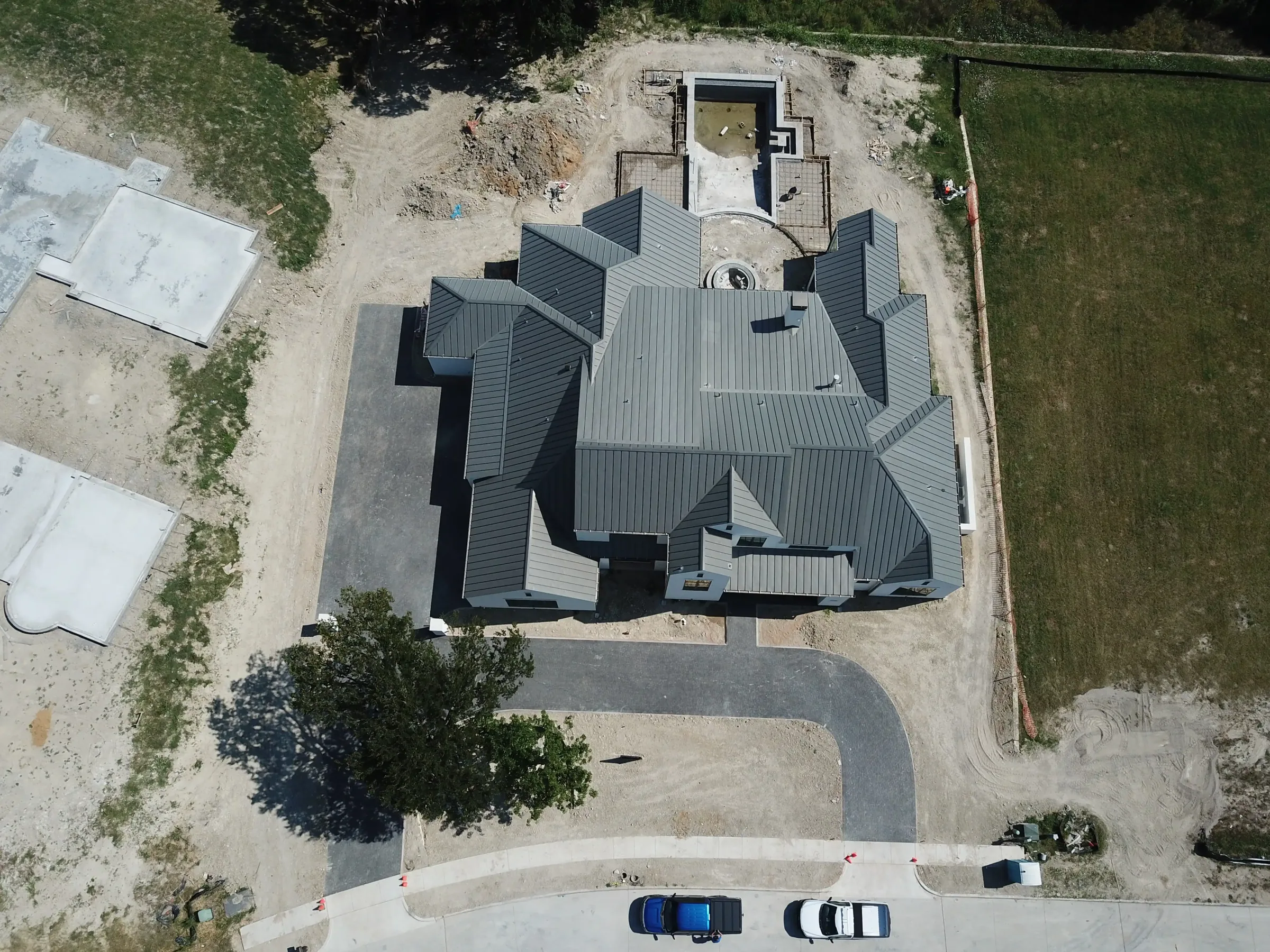 Aerial view of a custom home site across the lot, with the space empty on a job site