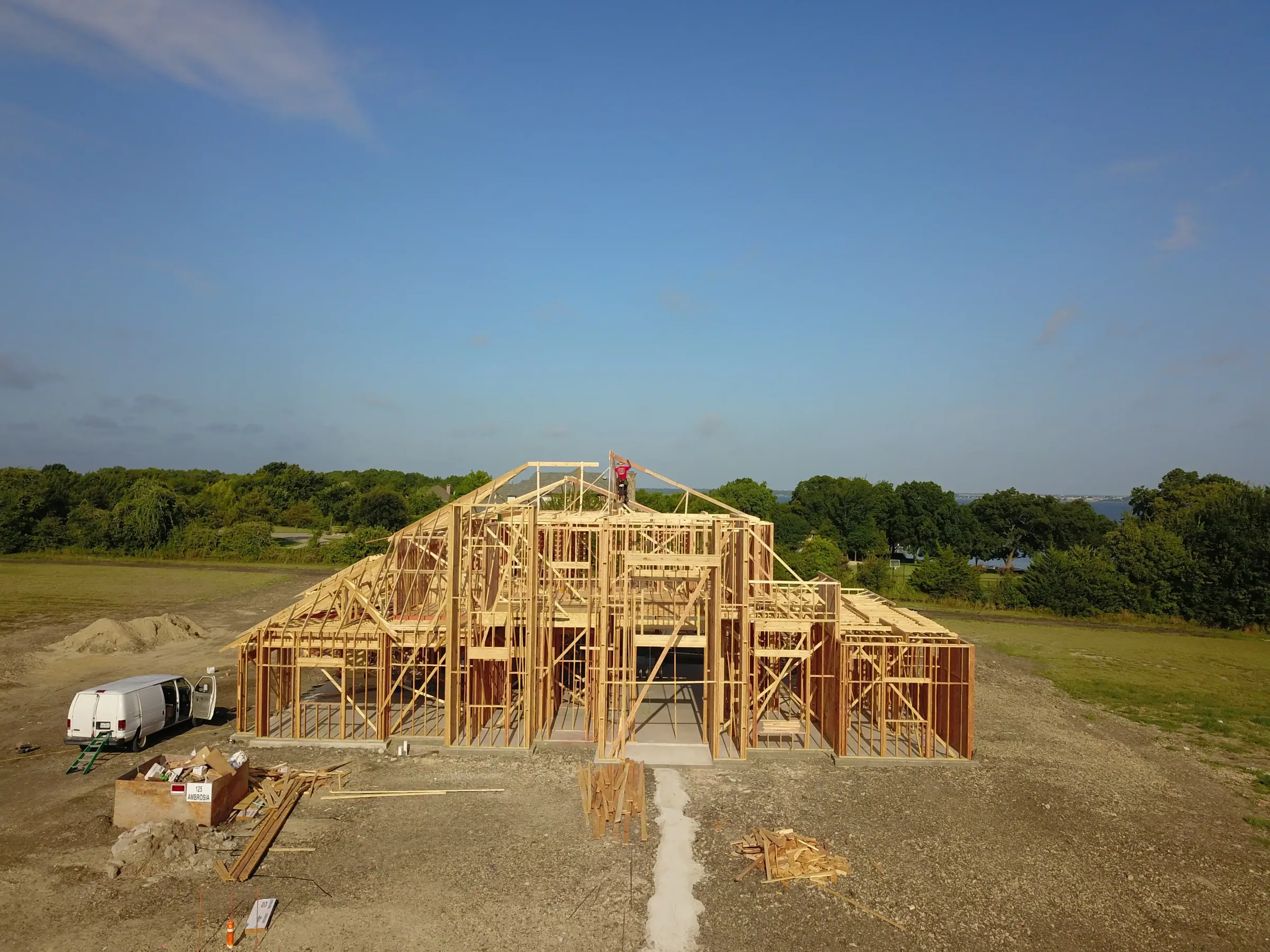 Aerial view of a custom home site from the north side, under work lights on a job site