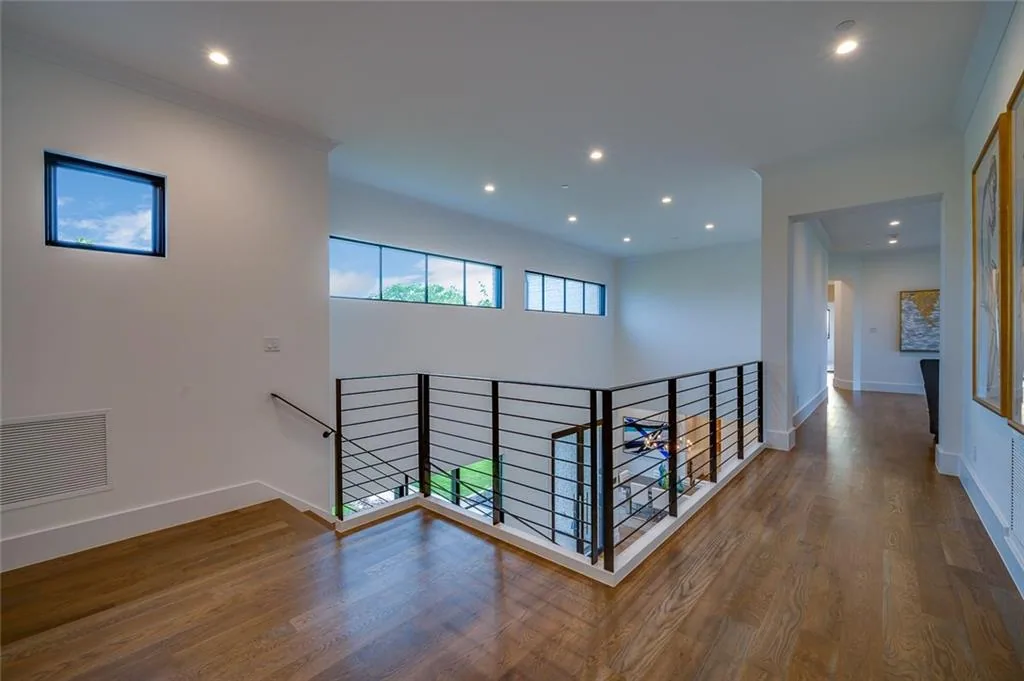 Upstairs landing with a black cable railing overlooking the stair and a row of clerestory windows in Ridge Lakes of Heath